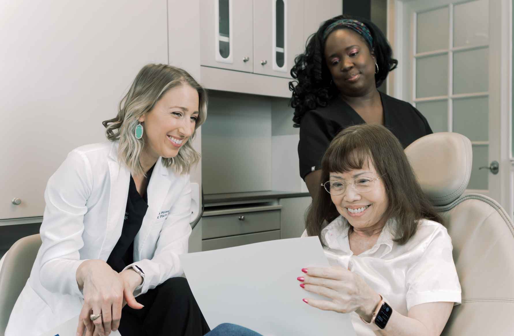 Photo of a woman in a dental chair talking with a dentist