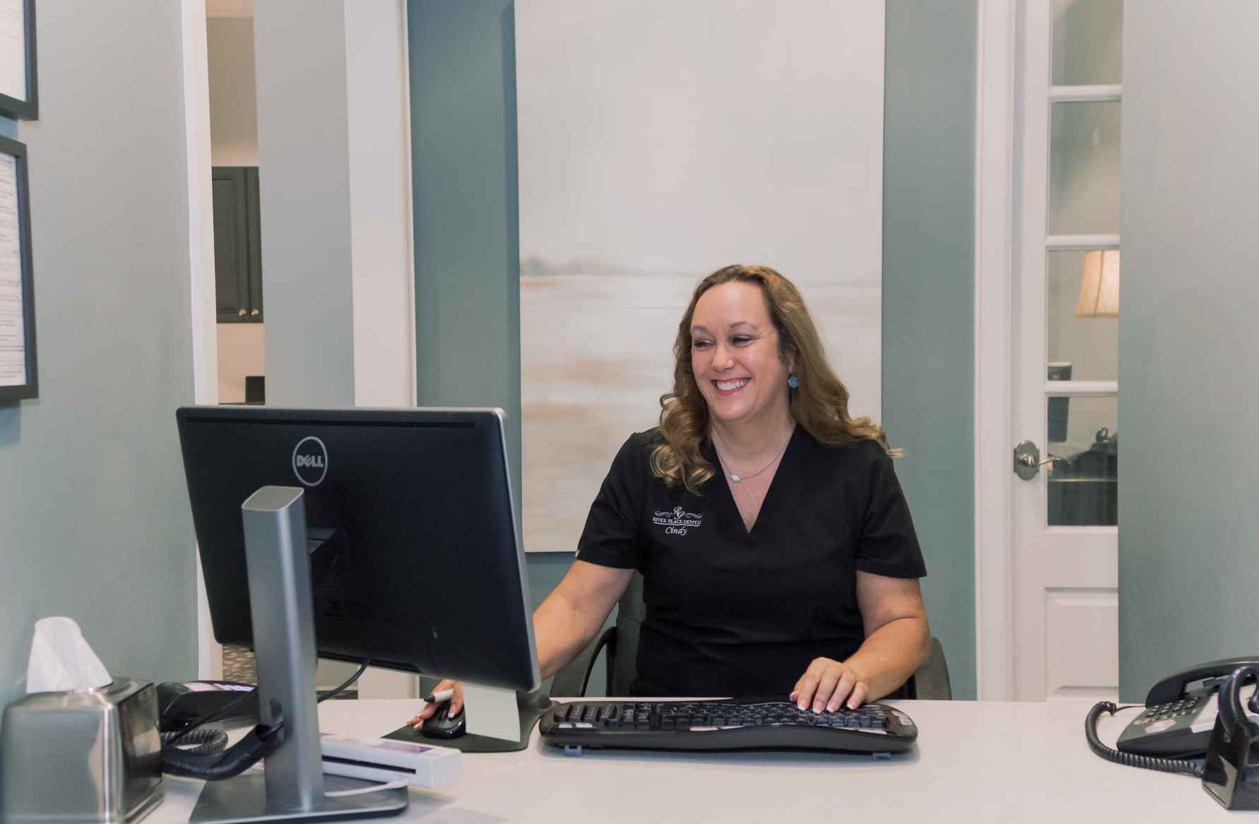 Photo of a team member using a computer at our front desk