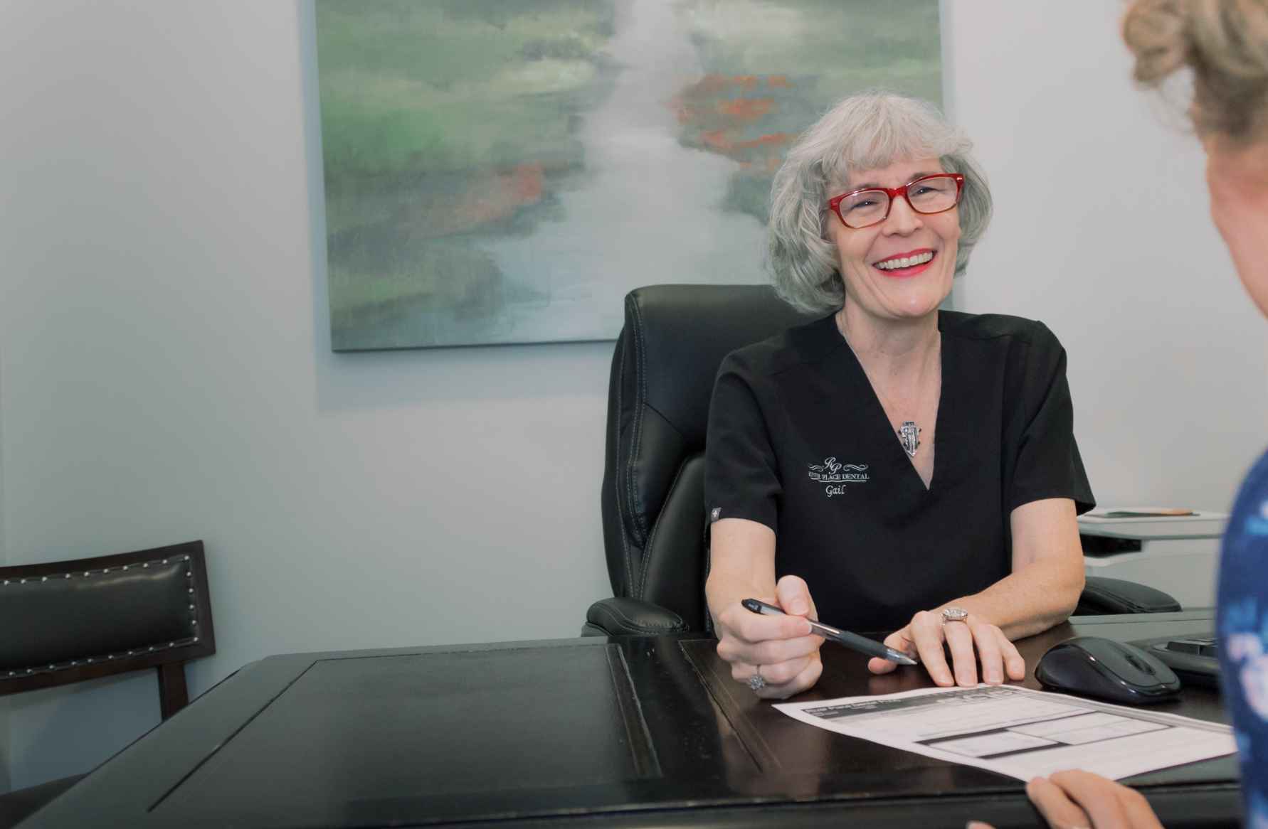 A team member sitting at a desk discussing a treatment plan with a patient