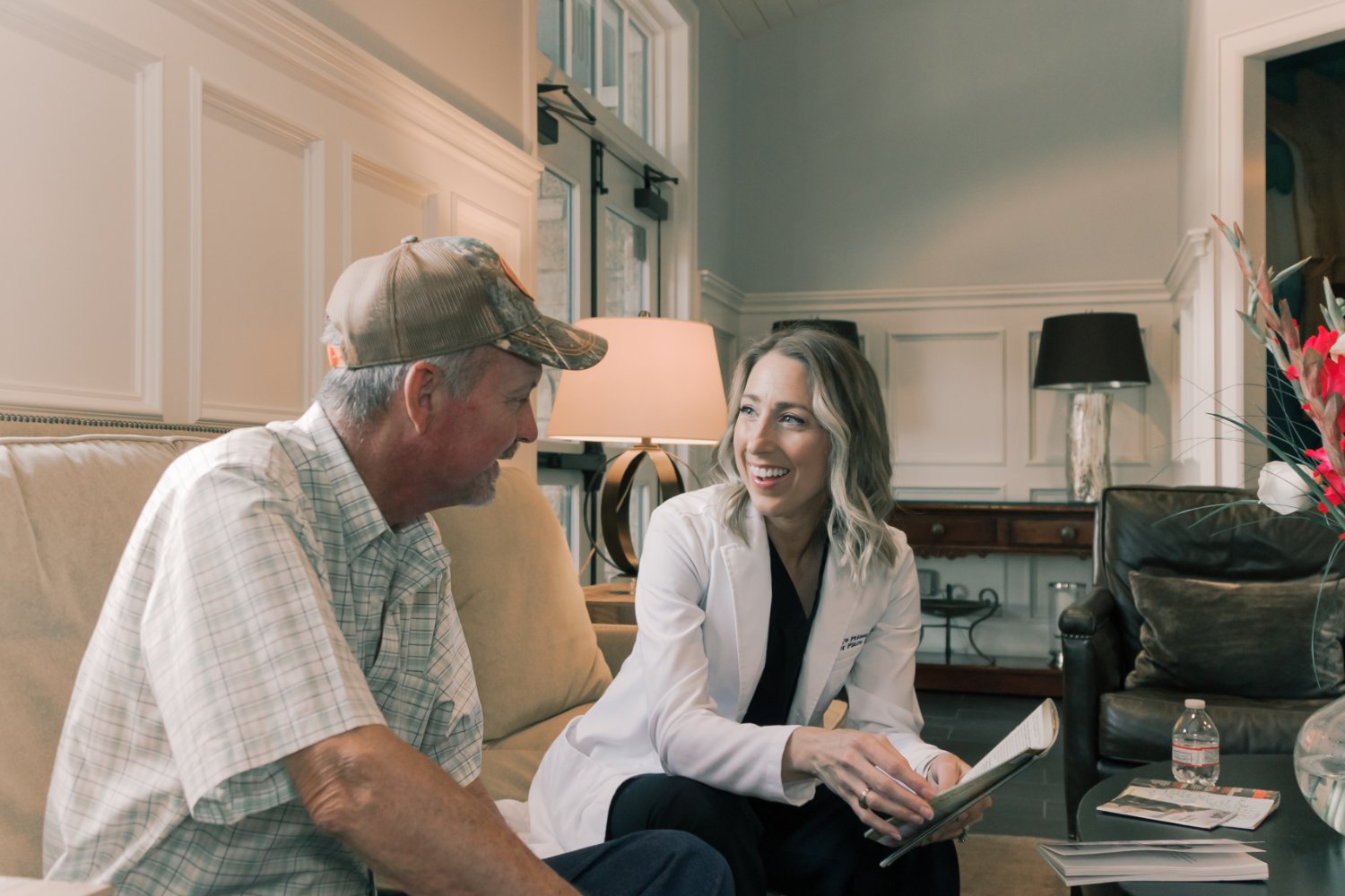 A dentist and patient sitting together on a sofa