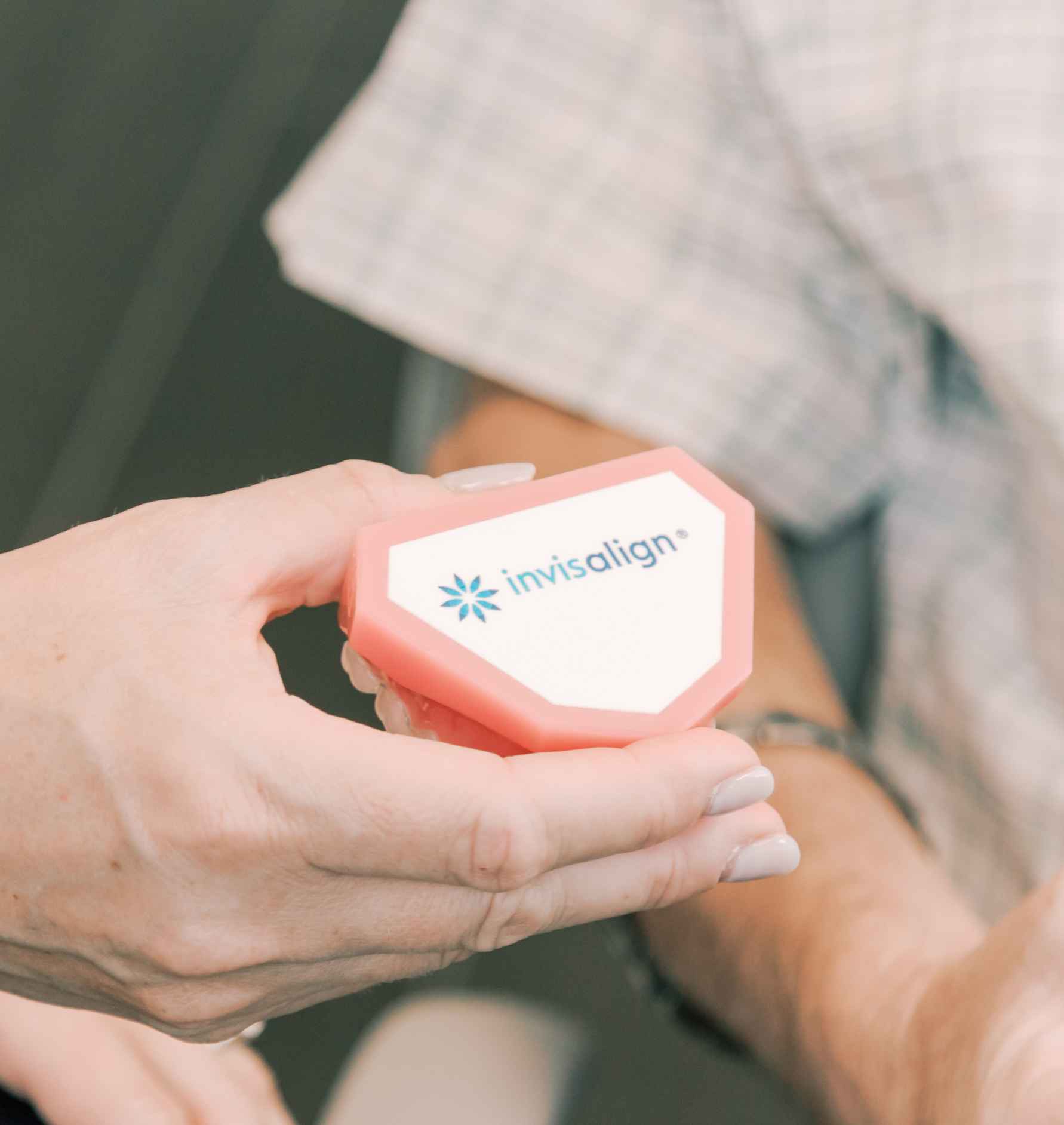 A hand holding an Invisalign demonstration model