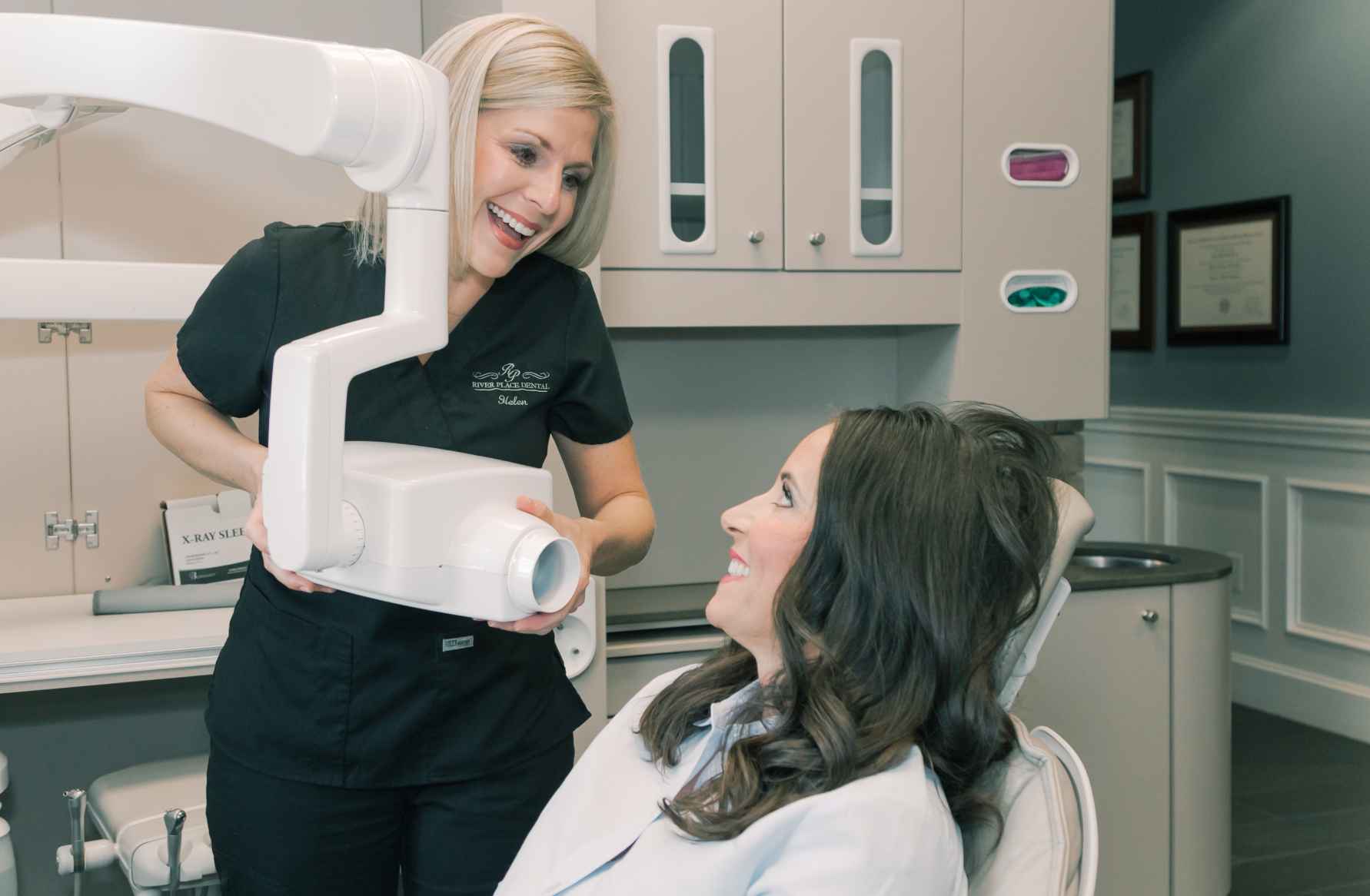 Photo of a woman and a team member holding an x-ray machine